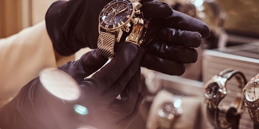 Close-up of the seller's hands in gloves shows the exclusive men's watch from the new collection